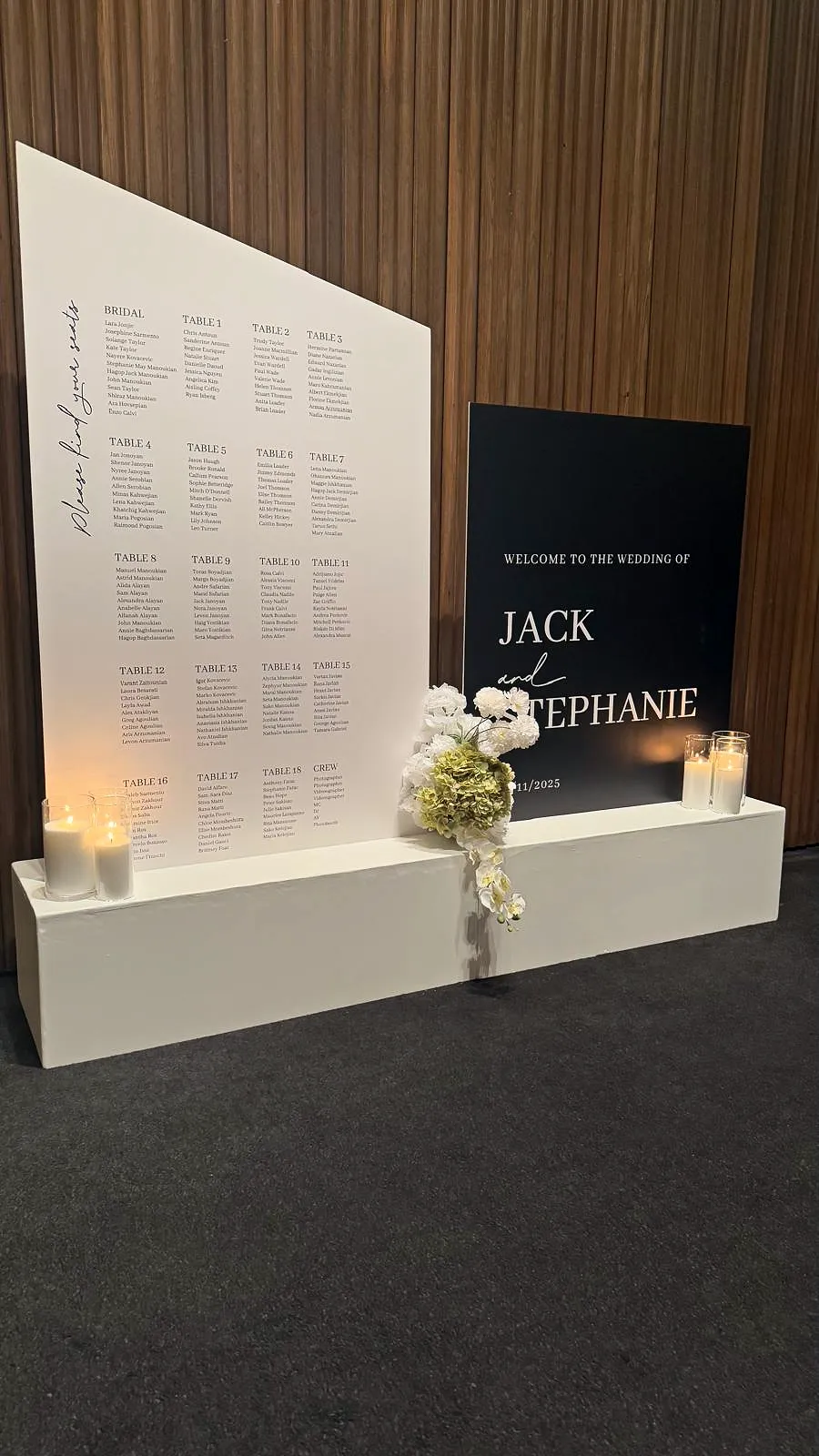 Wedding welcome sign and seating chart with candles and white florals