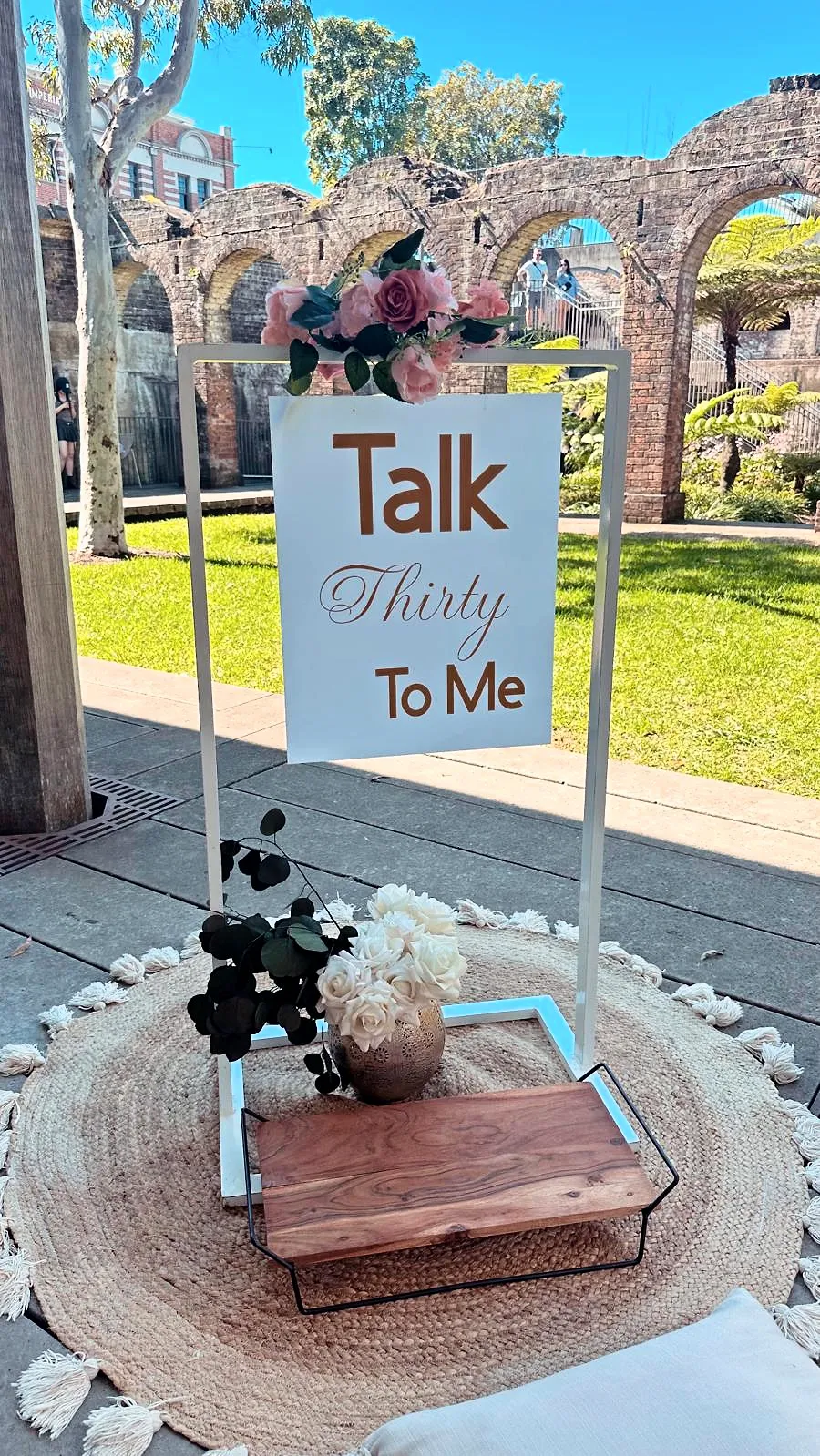 “Talk Thirty To Me” birthday sign on a stand with a styled table below